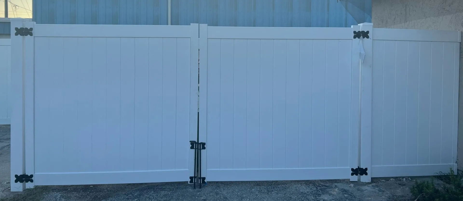 White vinyl fence with black hinges