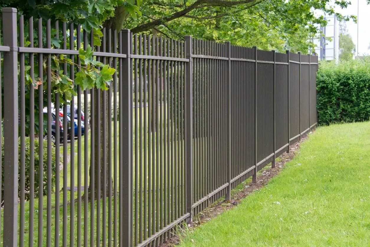 Long brown fence along green lawn