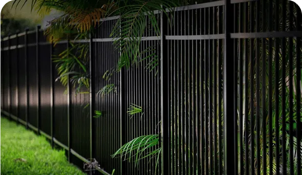 Greenery behind black iron fence