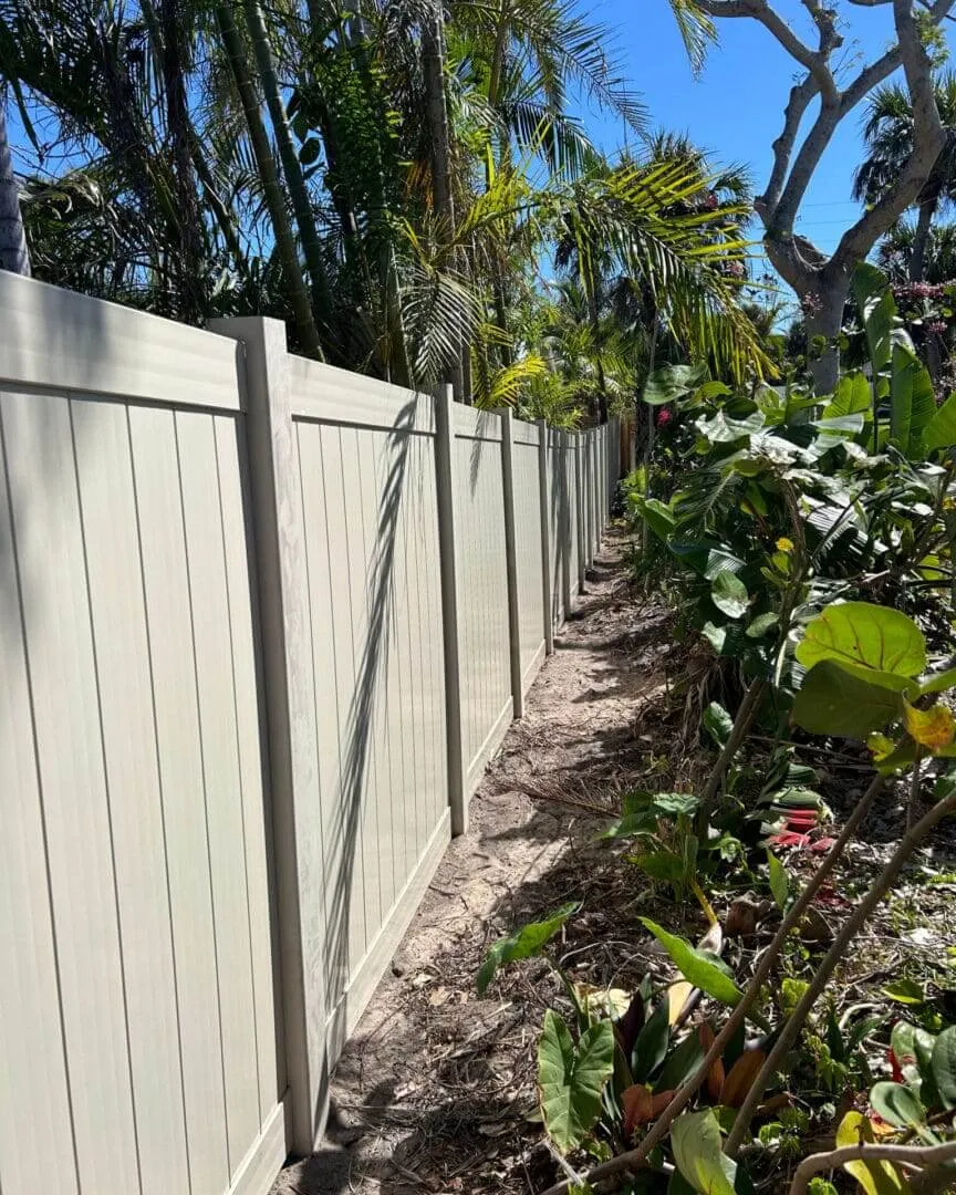 Tall fence beside lush tropical plants